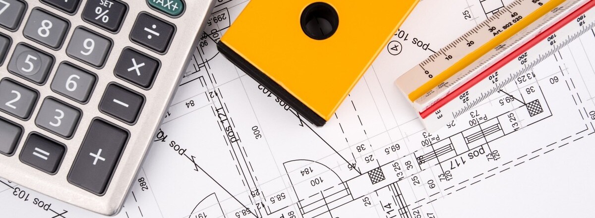 Крупный план архитектурных чертежей с калькулятором, жёлтой рулеткой и техническими карандашами сверху. Изображение передаёт темы планирования, строительства и инженерии.
